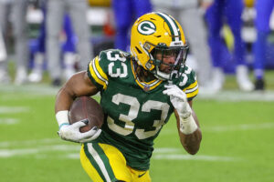 Aaron Jones #33 of the Green Bay Packers runs with the ball in the second quarter against the Los Angeles Rams during the NFC Divisional Playoff game at Lambeau Field on January 16, 2021 in Green Bay, Wisconsin